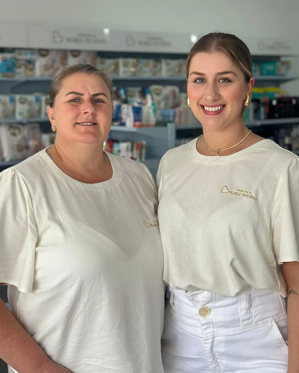 Maria Eugênia e Teti na farmácia, de uniforme branco